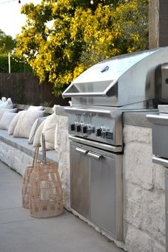 an outdoor bbq grill with pillows on the side