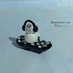 a black and white toy sitting on top of a checkered board with headphones