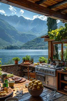 an outdoor kitchen with mountains in the background and a table full of food on it