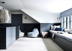 an attic bedroom with two beds and windows