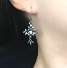 These silver gothic cross earrings, reflecting grunge jewelry aesthetics, feature cross charm dangles, making them a thoughtful gift for your Catholic friend or women who appreciate dainty accessories with a touch of edginess. 𝐃𝐄𝐓𝐀𝐈𝐋𝐒: ⭐️ Cross charm size is 1" ⭐️ Silver cross charms are silver plated over metal & fishhook earrings include high-quality stainless-steel ear wires which are made hypoallergenic and are safe for those with sensitive skin ⭐️ An essential to add to your jewelry Jewelry Cross, Edgy Earrings, Grunge Jewelry, Gothic Cross, Gothic Crosses, Earrings Aesthetic, Fish Hook Earrings, Cross Earrings, Cross Jewelry