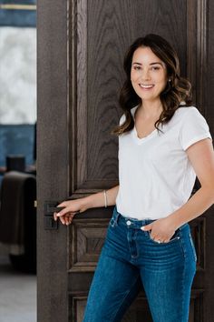 a woman standing in front of a wooden door