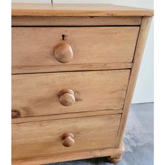 a close up of a wooden dresser with knobs on the top and bottom drawers