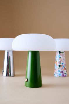 three lamps sitting on top of a table next to each other