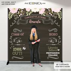 a woman standing in front of a graduation sign