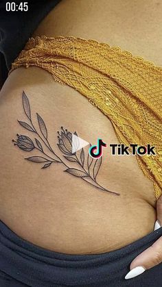 a woman's stomach with a flower tattoo on her belly and the words tiktok above it