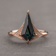 a close up of a ring with a black diamond in the center and diamonds around it