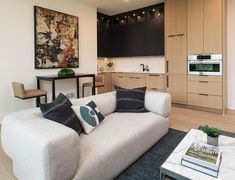 a living room filled with furniture next to a kitchen