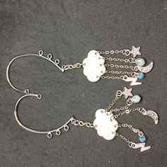 A Pair Of Ear Cuffs With White Clouds Holding Chains With Charms. Made By Me. Never Worn. Cloud Hair, Storm Clouds, White Clouds, Hand Crafted Jewelry, Ear Cuffs, Crafted Jewelry, Made By Me, Handcrafted Jewelry, Cute Hairstyles