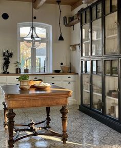 a kitchen with an old fashioned table in the center