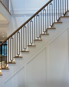 a white staircase with wooden handrails and glass doors