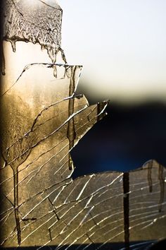 a broken glass window with the sun shining through it