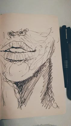 a drawing of a man's face is shown on a piece of paper next to a pen