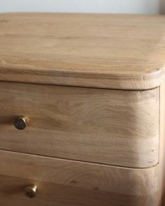 a close up of a wooden dresser with two drawers on each side and one drawer open