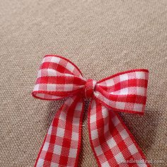 a red and white bow sitting on top of a carpet