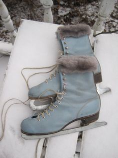 a pair of ice skates sitting on top of snow covered ground