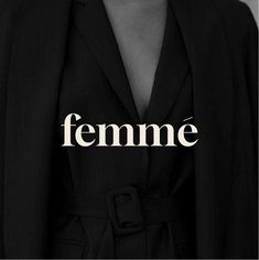 a woman in a black suit with the word feminine written on her chest and behind her