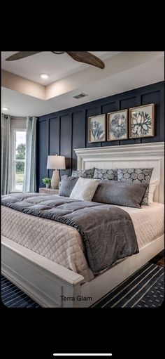 a large bed sitting in the middle of a bedroom next to a window with curtains