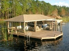 a dock with chairs on it in the middle of a body of water next to trees