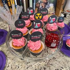 cupcakes with pink frosting and mickey mouse toppers on a clear plate