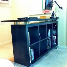 a television is on top of a bookcase in a room with carpeted floors