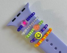 three bracelets with smiley faces and beads attached to each other on a purple watch band