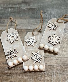 three tags with snowflakes on them sitting on a table