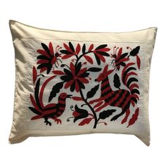 a white pillow with red and black designs on it