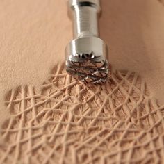 a close up view of a metal object on a beige surface with lines and circles