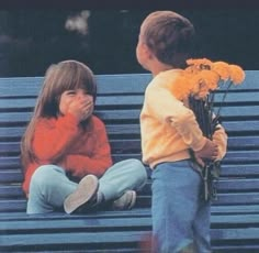 two children sitting on a bench with flowers in front of them and the caption says cute