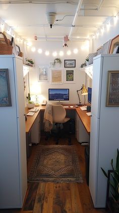 an office cubicle with desks, computer and lights on the ceiling above it