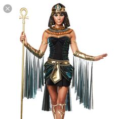 an egyptian woman dressed in costume and holding a staff