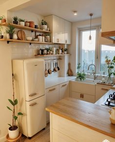 a white refrigerator freezer sitting inside of a kitchen next to a sink and stove