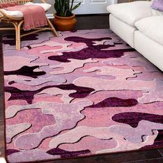 a living room with white couches and purple rugs