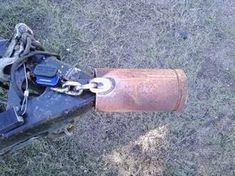 an old broken motorcycle sitting in the grass with chains on it's handlebars