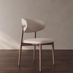 a white chair sitting on top of a hard wood floor next to a gray wall