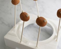 some brown and white cake pops on a stick