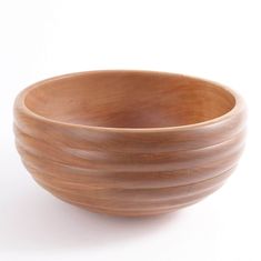 a wooden bowl sitting on top of a white table