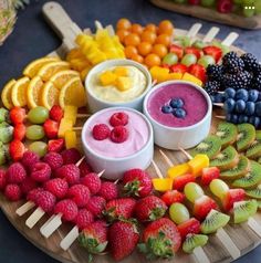 various fruits and dips arranged on a wooden platter