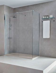 a walk in shower sitting on top of a white counter next to a towel rack