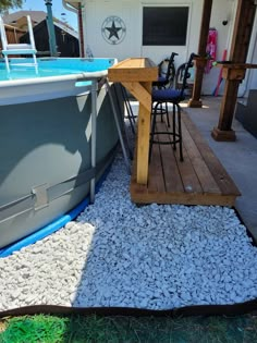 a boat sitting on top of a wooden deck next to a swimming pool with chairs around it