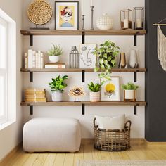 a living room with shelves filled with plants and pictures on it's wall above a footstool