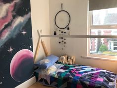 a child's bedroom with a space theme painted on the wall