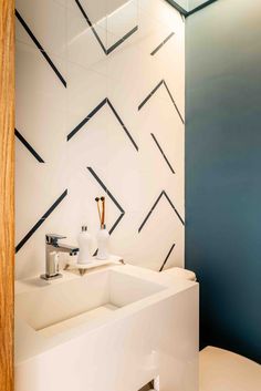 a white toilet sitting next to a bathroom sink under a mirror in a room with blue walls