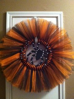 an orange and black wreath hanging on the front door, with a horse drawn on it