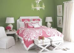 a bedroom with green walls, white furniture and pink comforter set on the bed