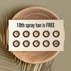 a sign that says, 10th spray tan is free on top of a wooden plate