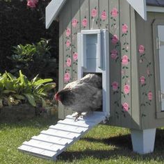 a chicken is standing on top of a small house