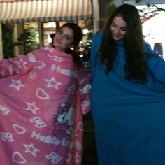 two women wrapped up in pink and blue towels with hello kitty designs on them, standing next to each other