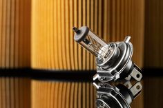 a close up of a carburet on a reflective surface with wood in the background